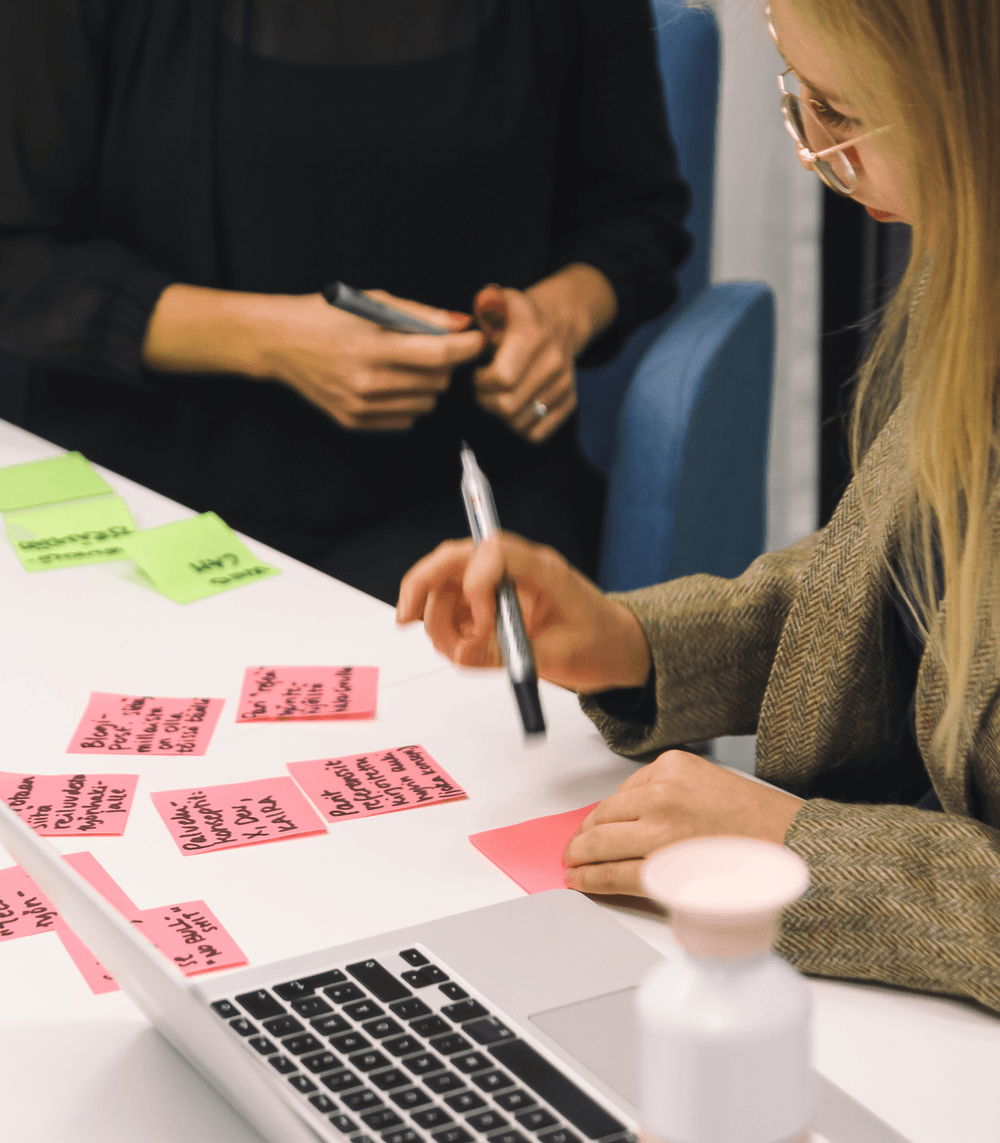 Two people discussing something over post-it notes.